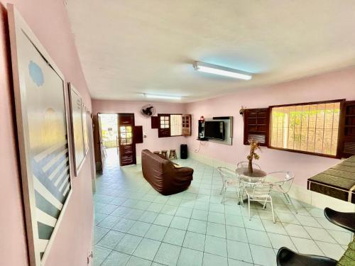 a living room with pink walls and a table and chairs at Casa Ilha de Itamaracá in Vila Velha