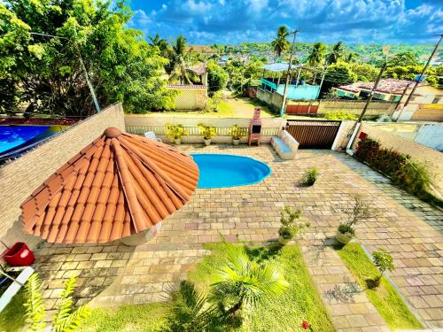a patio with an umbrella and a pool at Casa Ilha de Itamaracá in Vila Velha