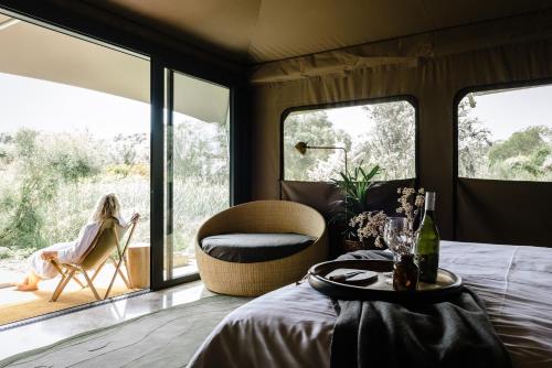 una mujer sentada en una silla en una habitación con ventanas en Peninsula Hot Springs en Fingal