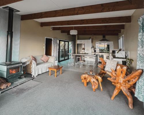 a living room with a couch and a stove at Evergreen Escape Hokitika in Hokitika