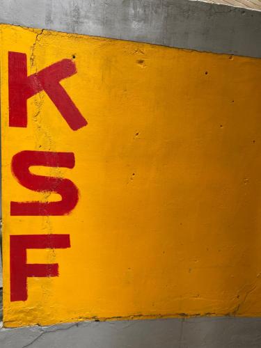 a yellow sign on the side of a wall at KSF B&B in Tainan
