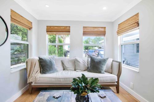 a white couch in a living room with windows at Croton Cottage - Downtown WPB guest house in West Palm Beach