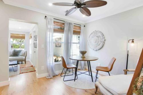 a living room with a table and chairs and a ceiling fan at Croton Cottage - Downtown WPB guest house in West Palm Beach