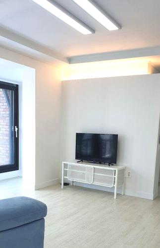 salon z płaskim telewizorem na białej ścianie w obiekcie Elle House w mieście Jeonju