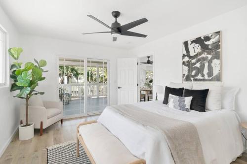 a white bedroom with a bed and a ceiling fan at Serenity by the Sea Ultimate Beachfront Escape in Hauula