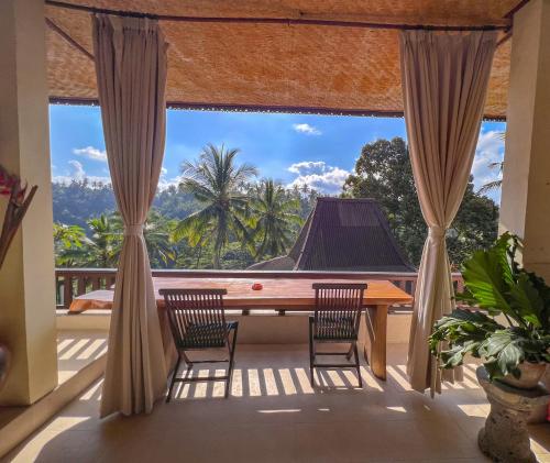 a room with a table and chairs on a balcony at Made Punia's Jungle in Ubud