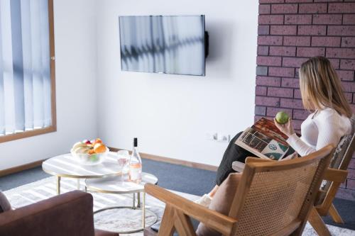 a woman sitting in a chair reading a magazine at Madsen Retreat in Penguin