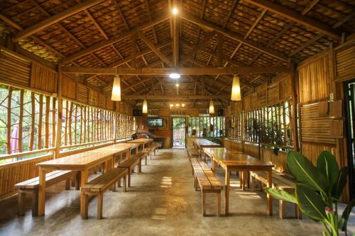 ein Esszimmer mit Holztischen und Bänken in der Unterkunft Tinipak Lodge in Tanay
