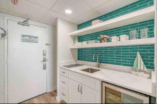 a kitchen with a sink and a green tile wall at Soul Sanctuary-Direct oceanfront-Million dollars view-King bed-Free Parking-Self check-in in Myrtle Beach