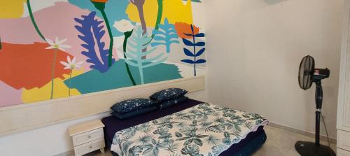 1 dormitorio con 1 cama con una pintura en la pared en Beatiful Afamosa Golf Resort Private villa with pool 3 rooms lot 1280 bumiputra only, en Kampong Alor Gajah