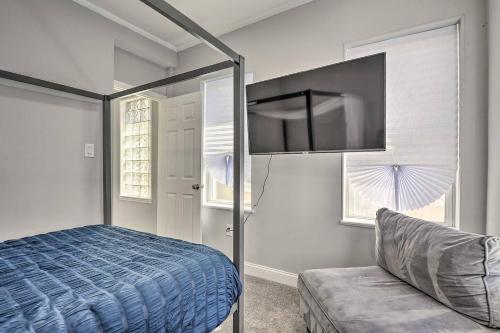 a bedroom with a bed and a couch and windows at Baltimore Abode, Walk to Cross Street Market! in Baltimore