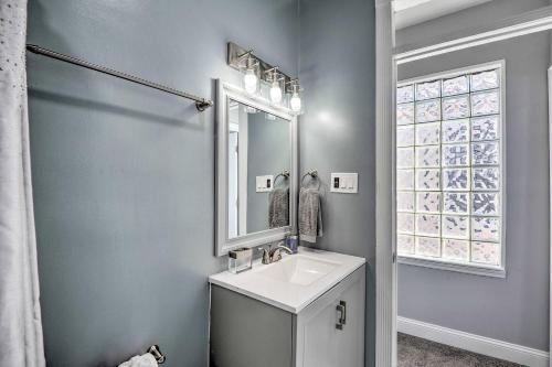 ein Bad mit einem Waschbecken, einem Spiegel und einem Fenster in der Unterkunft Baltimore Abode, Walk to Cross Street Market! in Baltimore