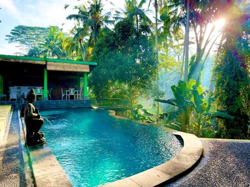 una mujer sentada frente a una piscina en Dupa Ubud, en Ubud