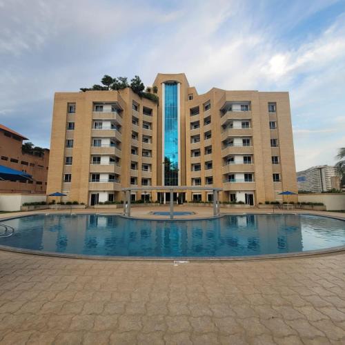 um grande edifício com uma grande piscina em frente em Apartamento Deluxe Isla Margarita - Costa Azul em Porlamar