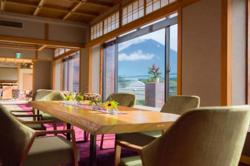 a dining room with a table and chairs and a large window at Kaneyamaen in Fujiyoshida