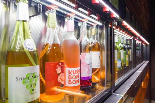 a row of bottles of wine in a refrigerator at Bessho Sasa in Fujiyoshida