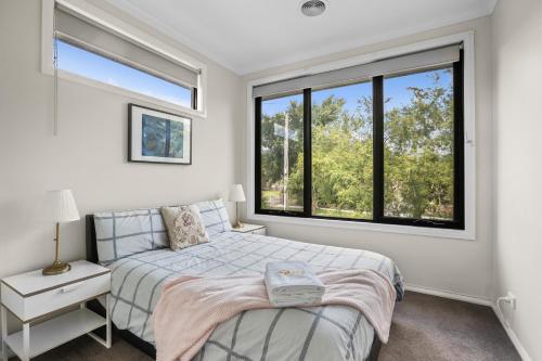 a bedroom with a bed and two windows at New Comfort house near Box Hill in Nunawading