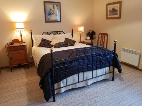 a bedroom with a bed and two lamps and a table at Cornwall Cottage in Cambridge