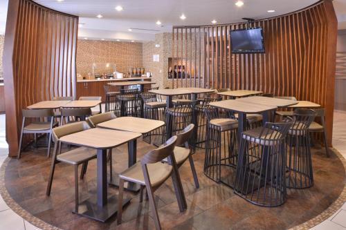 a restaurant with tables and chairs and a tv on a wall at SpringHill Suites Las Vegas Henderson in Las Vegas