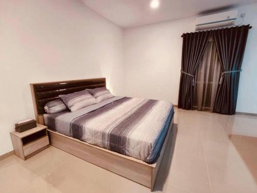 a bedroom with a bed in a room with a window at Binbaba Homestay - Grand Maganda in Batam Center