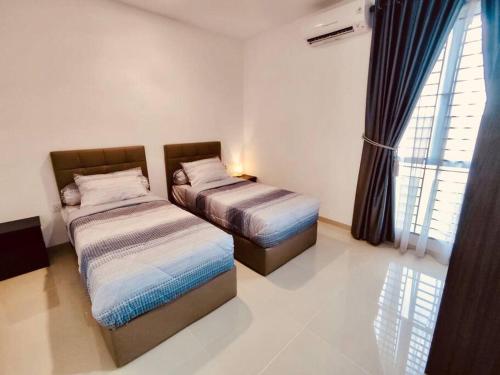 two beds in a room with a window at Binbaba Homestay - Grand Maganda in Batam Center