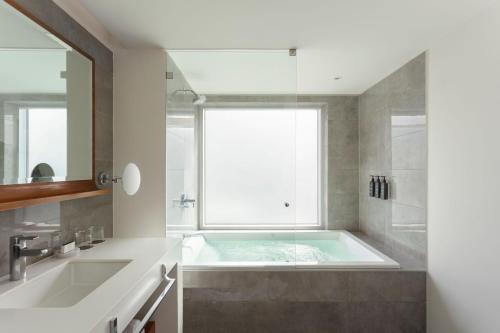 a bathroom with a tub and a window at Courtyard by Marriott Lima Miraflores in Lima