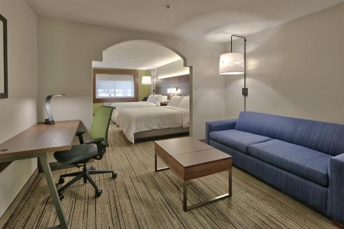 Habitación de hotel con sofá y cama en Holiday Inn Express & Suites Portales, an IHG Hotel, en Portales
