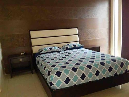a bedroom with a bed with a blue and white comforter at Deluxeguesthouse/vía Spondylus in Manta