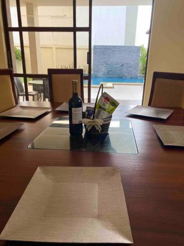 a bottle of wine sitting on top of a wooden table at Deluxeguesthouse/vía Spondylus in Manta