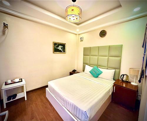 a bedroom with a white bed with a green headboard at Anh Duy Hotel - Nguyễn Công Trứ The Bitexco Neighbour in Ho Chi Minh City