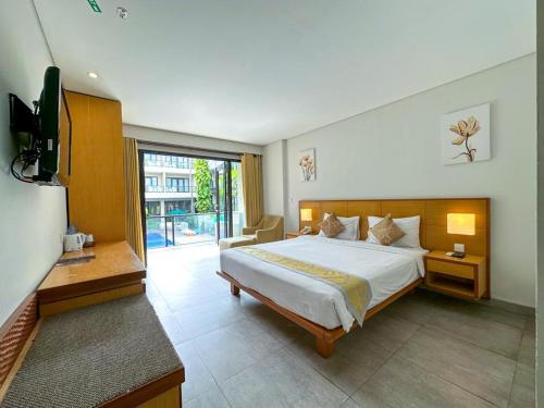 a bedroom with a large bed and a television at Dekuta in Kuta