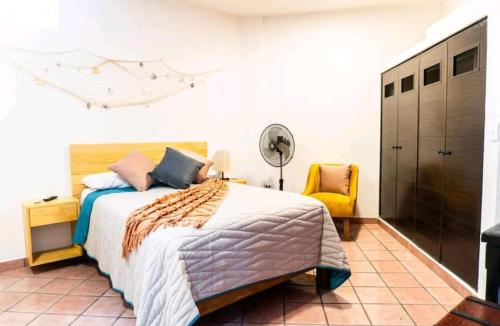 um quarto com uma cama e uma cadeira amarela em Room in Guest room - Suite 2 Vena Close to buses and supermakets em Puerto Vallarta