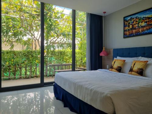 a bedroom with a large bed and a large window at Oceanami Resort Sea View in Long Hai