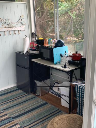 a kitchen with a table and a counter with dishes at Cozy jungle boat hideaway with stunning ocean view in Kealakekua