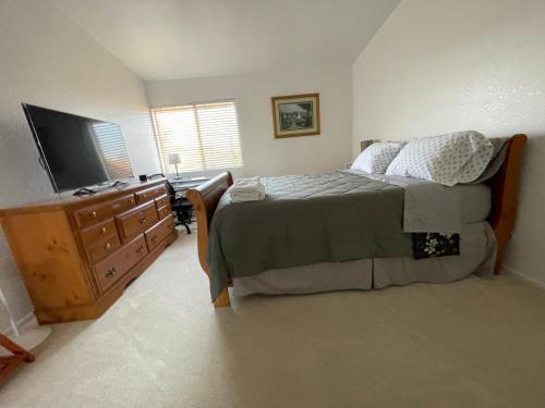 a bedroom with a bed and a dresser with a television at Ploy in Monterey Park