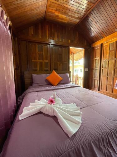 a bed with a white dress on it in a room at The Best Garden resort in Sichon