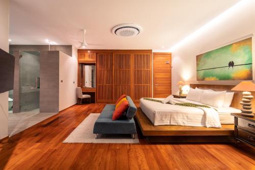 1 dormitorio con 1 cama grande y 1 sofá azul en Luxurious SeaView 4br Private Pool Villa by Intira Villas, en Rawai Beach