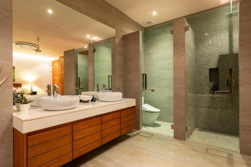 y baño con 2 lavabos y ducha. en Luxurious SeaView 4br Private Pool Villa by Intira Villas, en Rawai Beach