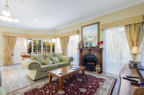 a living room with a couch and a fireplace at Durham Lodge Bed & Breakfast in Perth