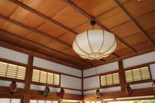 a chandelier hanging from a wooden ceiling with windows at Wakamizu Minpaku in Tōganemachi