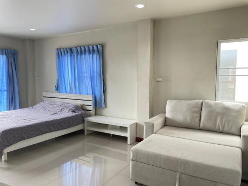 a bedroom with a bed and a couch and a chair at House near Suvarnabhumi Airport in Ban Hua Takhe