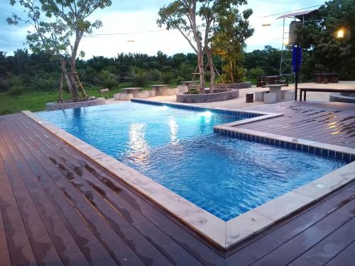 a swimming pool with a wooden deck and a swimming poolvisor at The Best Garden resort in Sichon