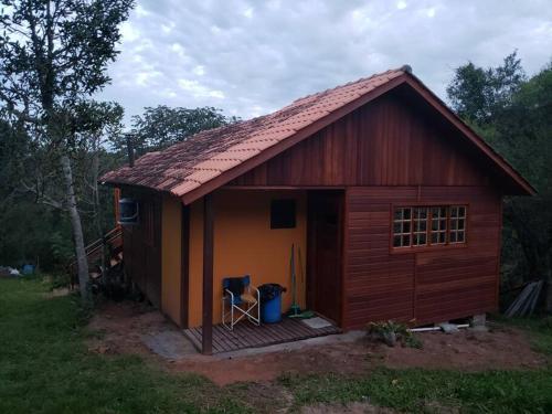 uma pequena casa com um deque num quintal em Cabana Terra Nativa Reserva Natural em Glorinha