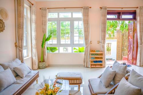 a living room with two couches and a large window at Dream House - Đà Lạt in Da Lat