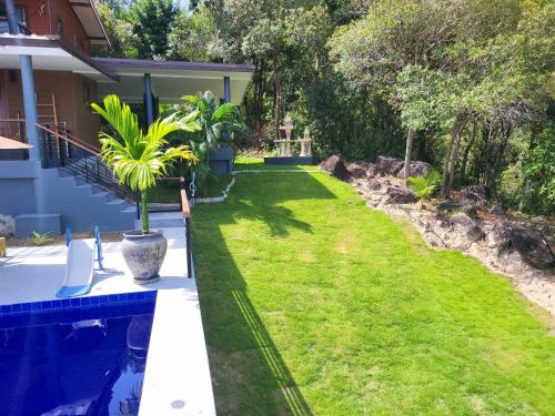 a backyard with a lawn and a swimming pool at Lost Paradise 1 in Hinkong
