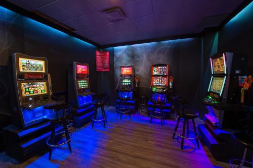 a room with four slot machines and stools at Hotel du Fjord in Saguenay