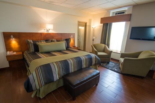 a hotel room with a bed and a tv at Hotel du Fjord in Saguenay