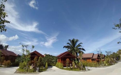 een rij huizen met palmbomen voor hen bij The Best Garden resort in Sichon
