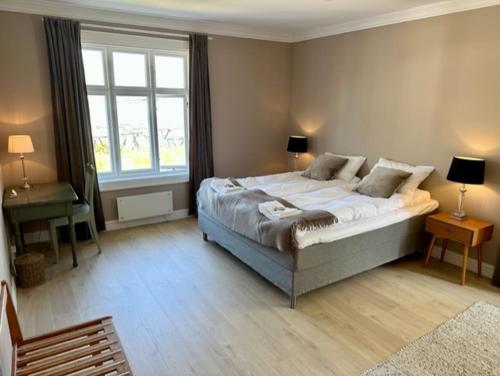 um quarto com uma cama grande e uma janela em Det Gamle Hotellet Guesthouse em Reine