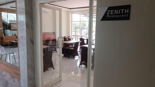a restaurant entrance with a sign on the door at Hotel Apex Dobo in Dobo
